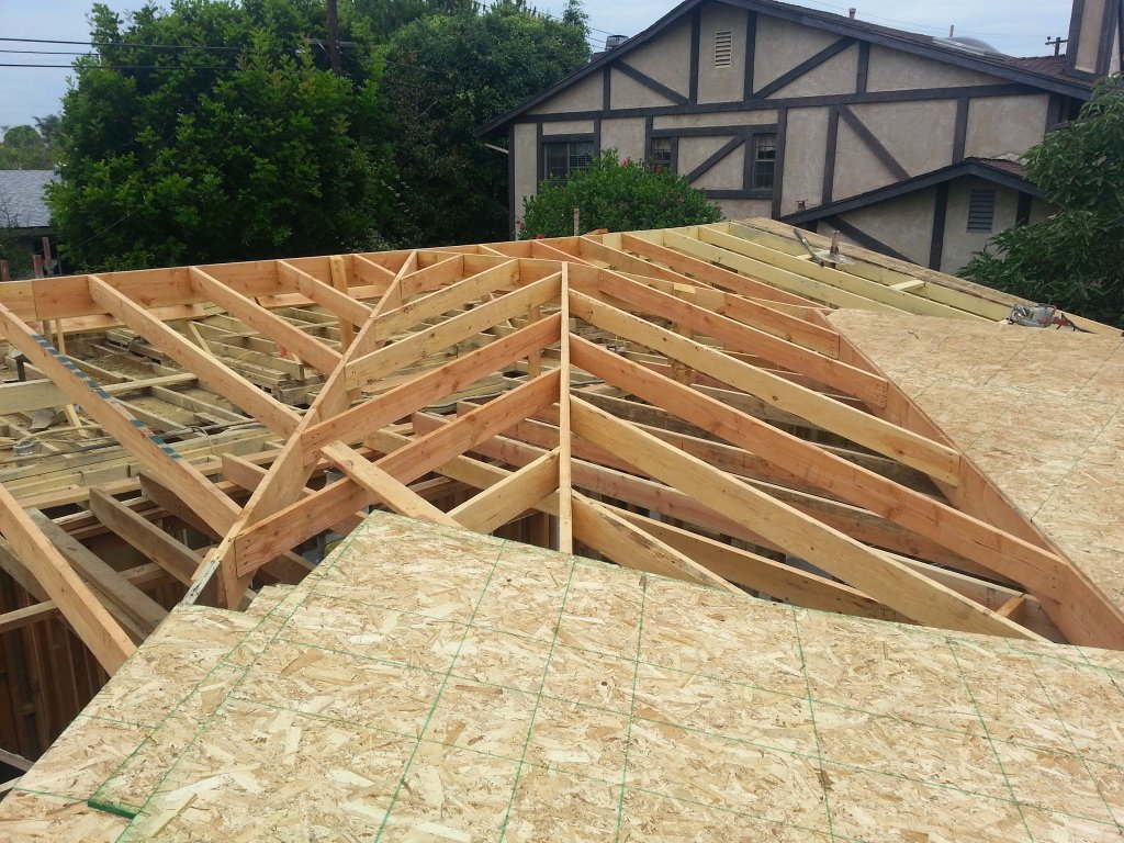 New truss framing and OSB roof sheathing during fire damage rebuild in Orange County