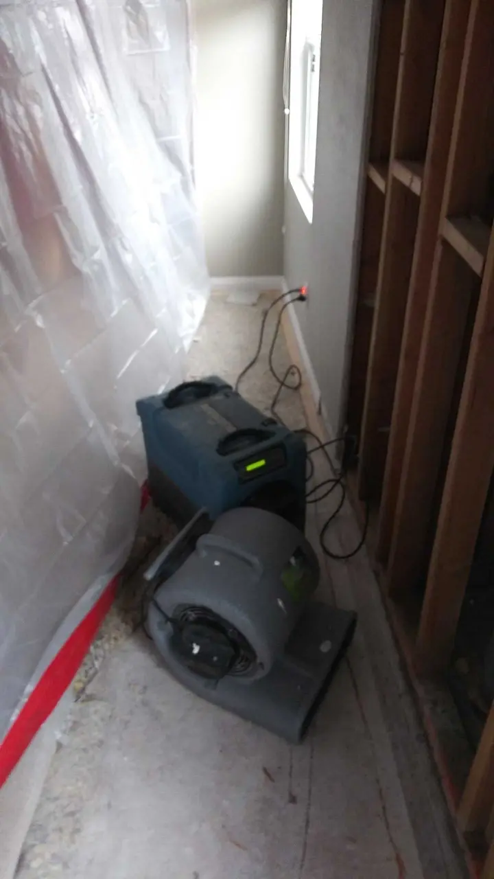 Containment and air mover during dry-out during Beaumont water damage restoration project by PL Builders