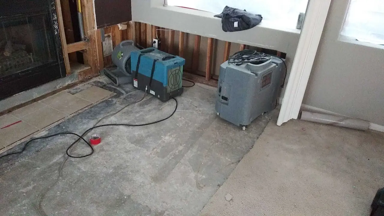 Drying equipment at the opened fireplace wall during Beaumont water damage restoration project by PL Builders