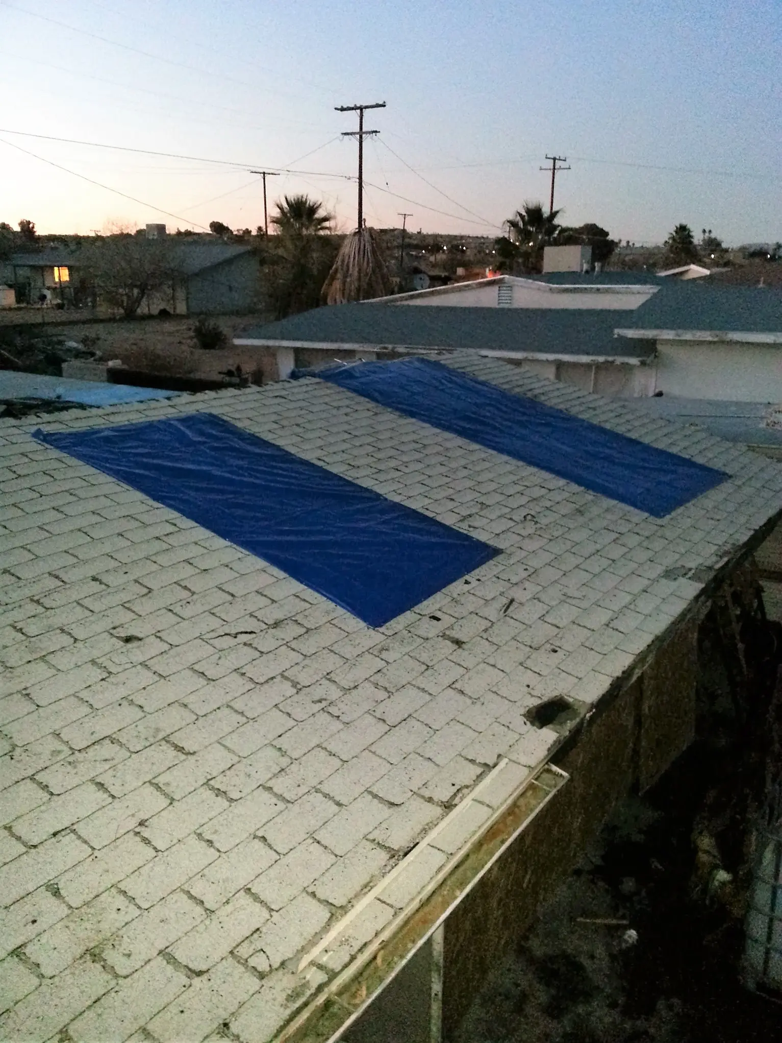Twentynine Palms garage fire emergency board up and roof tarp project by PL Builders showing roof tarp protection after garage fire damage