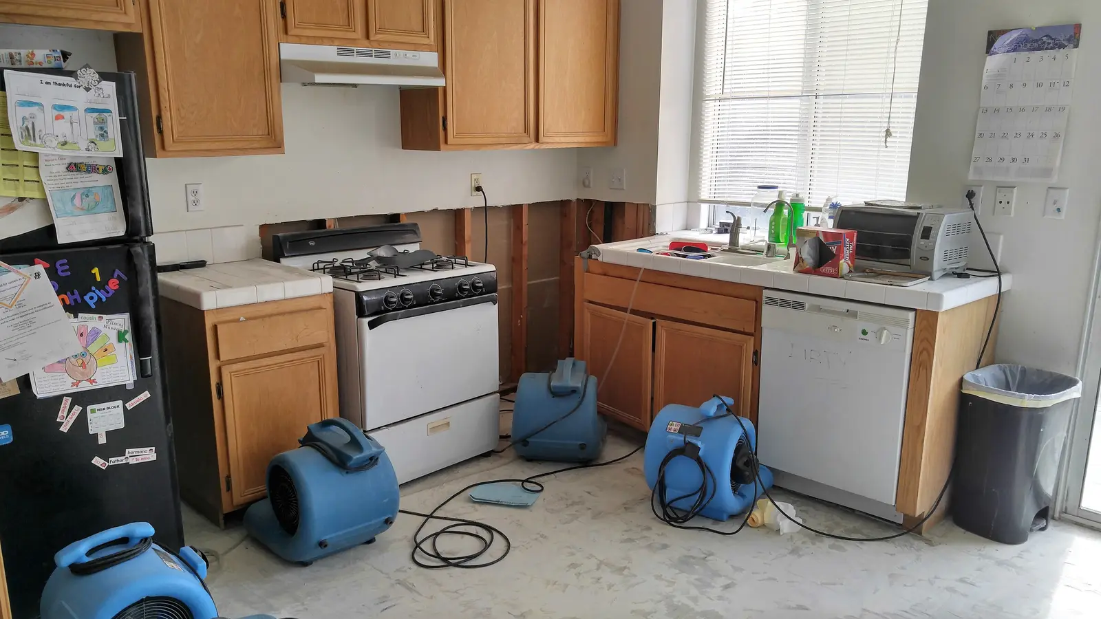 Jurupa Valley burst pipe kitchen water damage restoration project by PL Builders showing air movers set in kitchen for burst pipe dry out