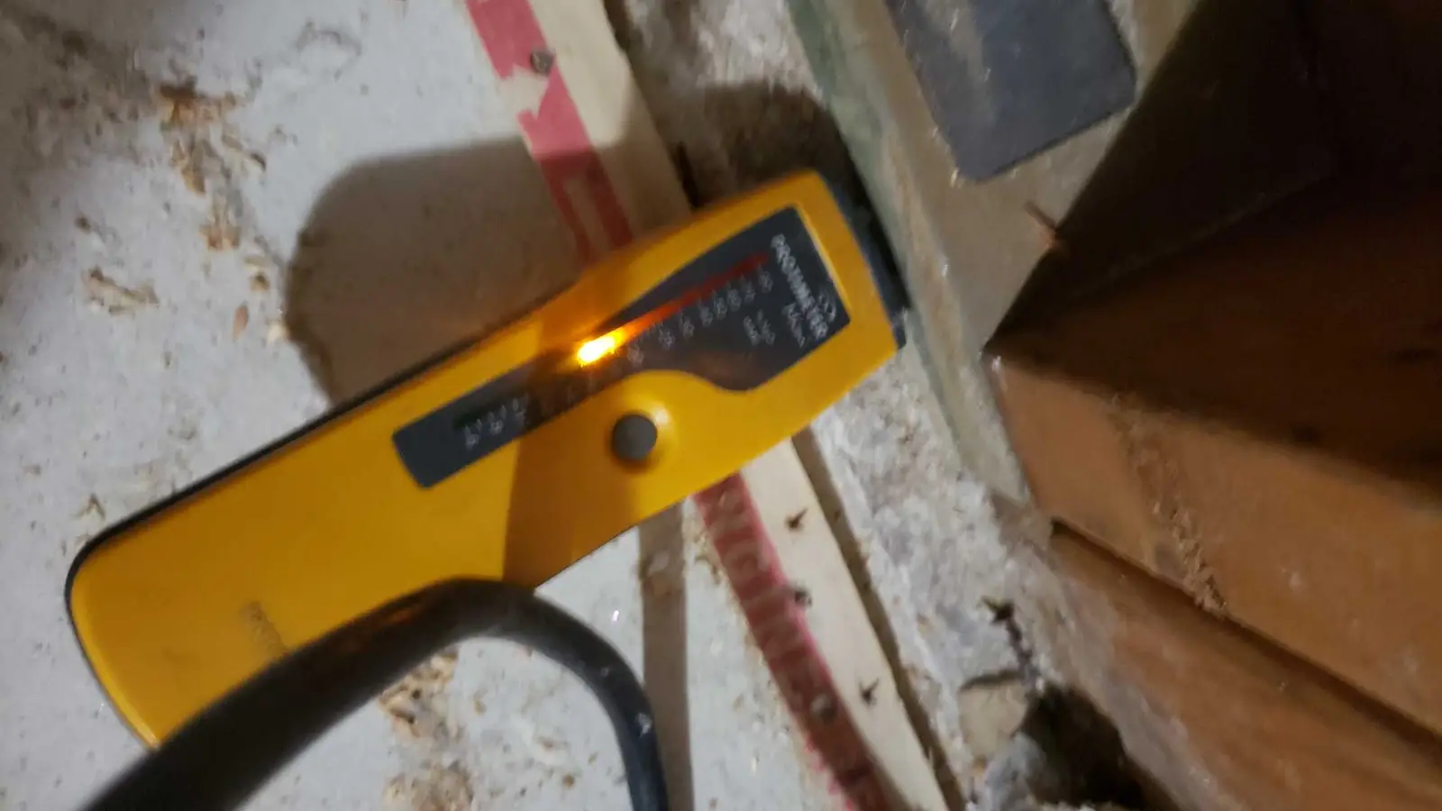 Lake Elsinore repipe water damage mitigation project by PL Builders showing moisture meter reading near baseboard removal
