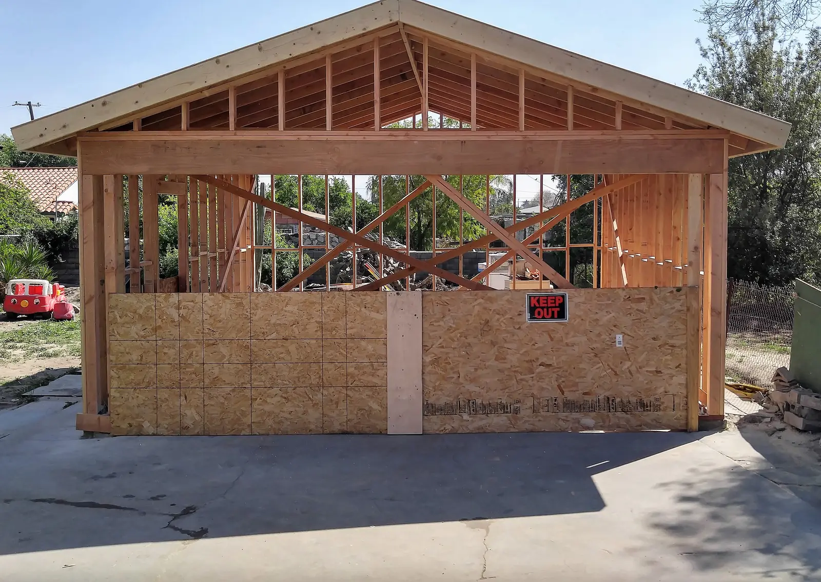 San Bernardino garage fire damage rebuild project by PL Builders showing garage wall sheathing and roof framing during fire rebuild