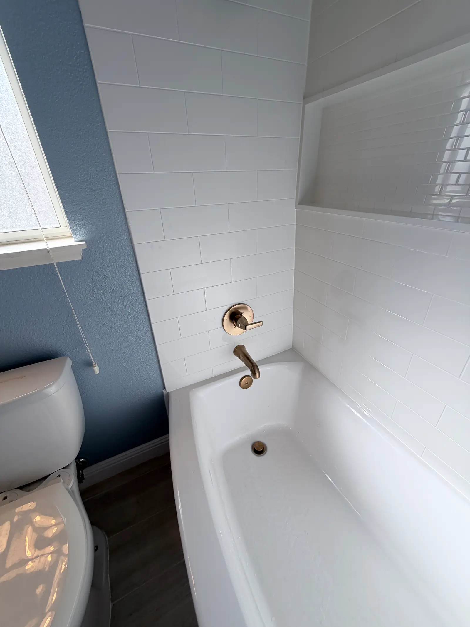 Bathroom tub and wall finish detail during Temecula water damage restoration project by PL Builders
