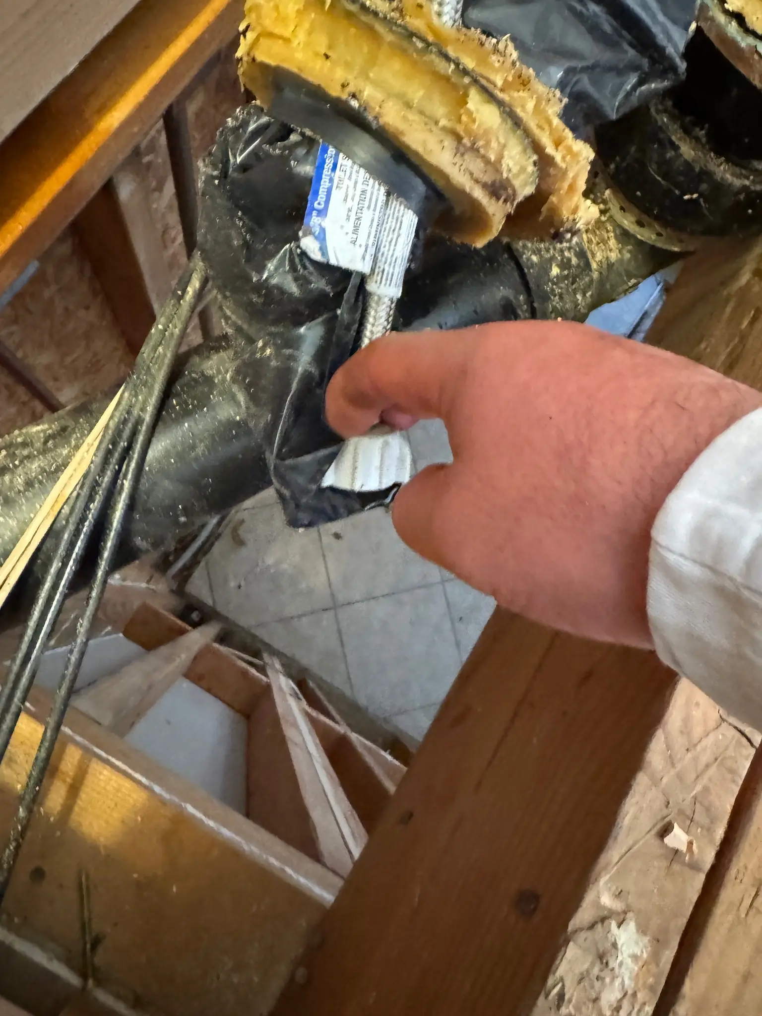 Drain connection documented inside opened bathroom floor during Temecula water damage restoration project by PL Builders