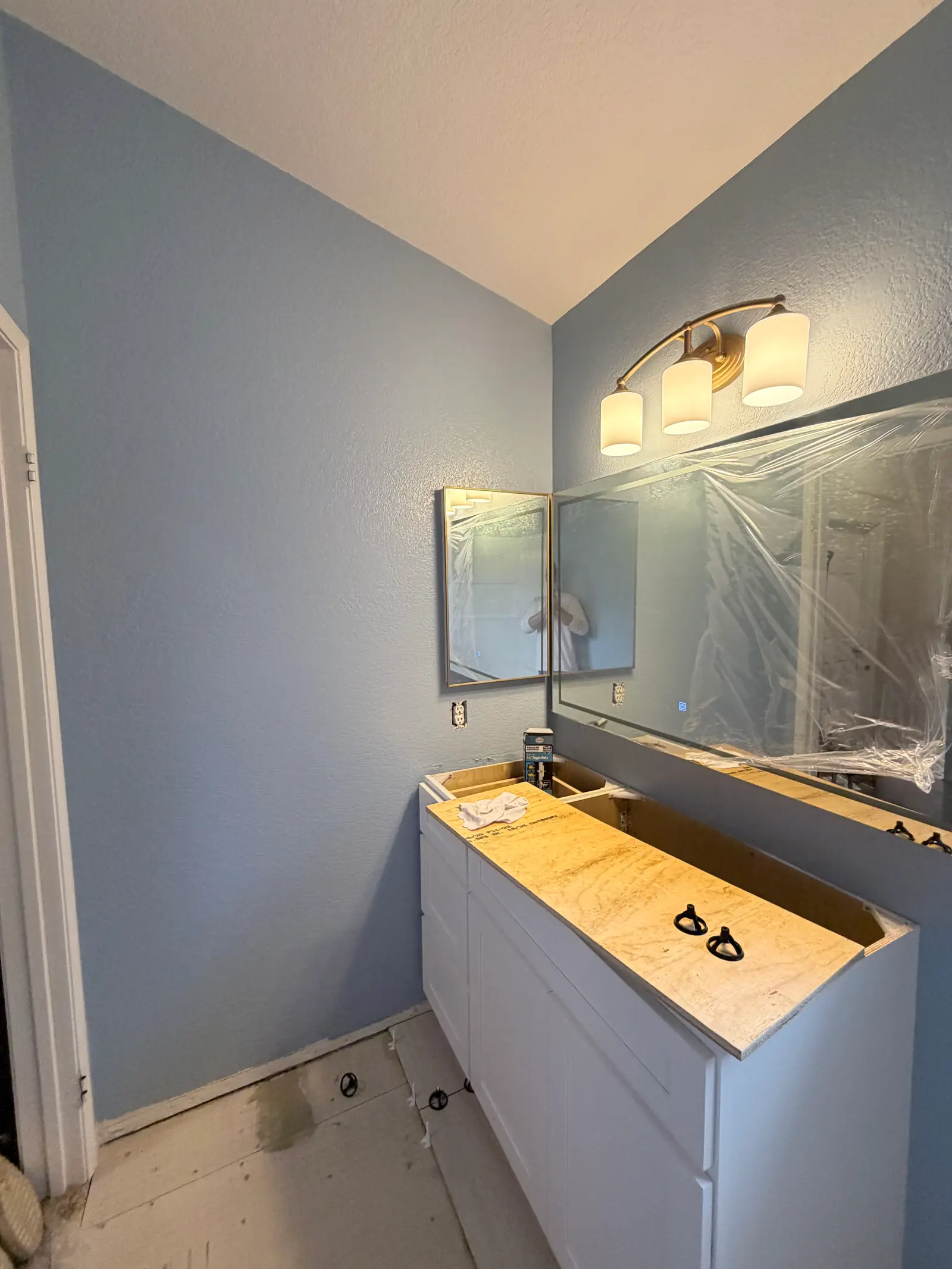 Finished bathroom vanity and mirror area during Temecula water damage restoration project by PL Builders