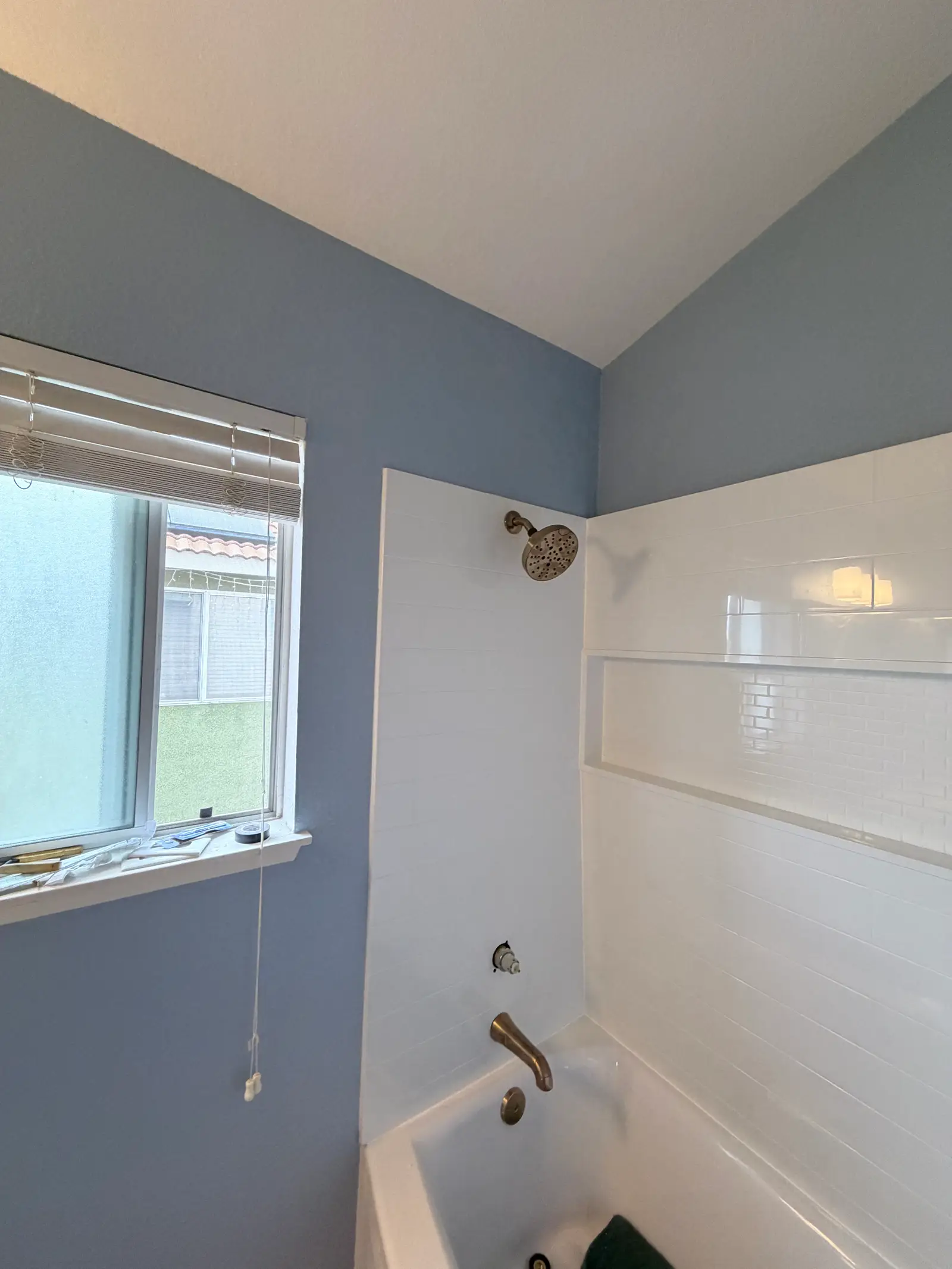 Finished bathroom wall and tub surround during Temecula water damage restoration project by PL Builders