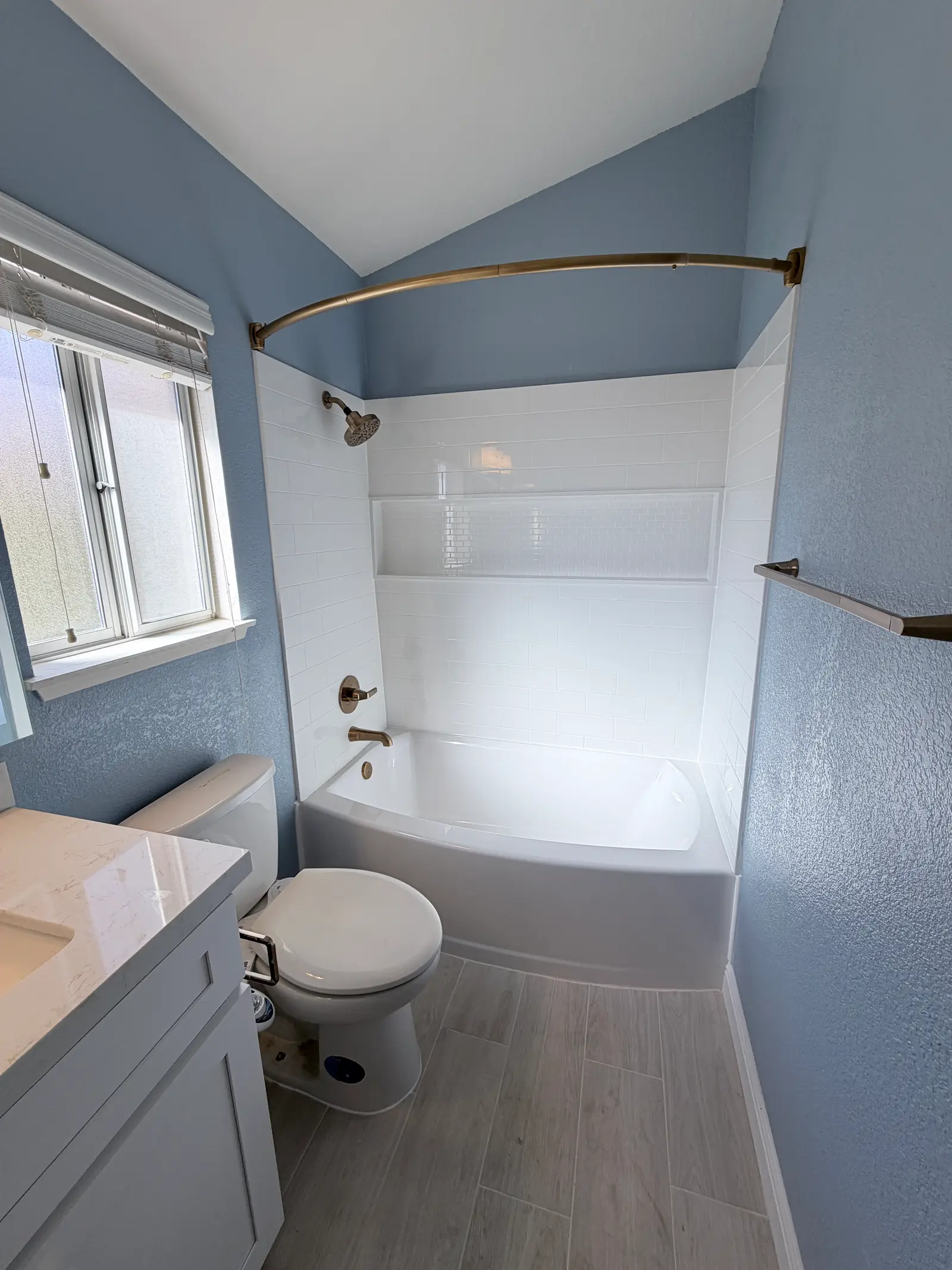 Finished bathroom with vanity, toilet, and tub during Temecula water damage restoration project by PL Builders