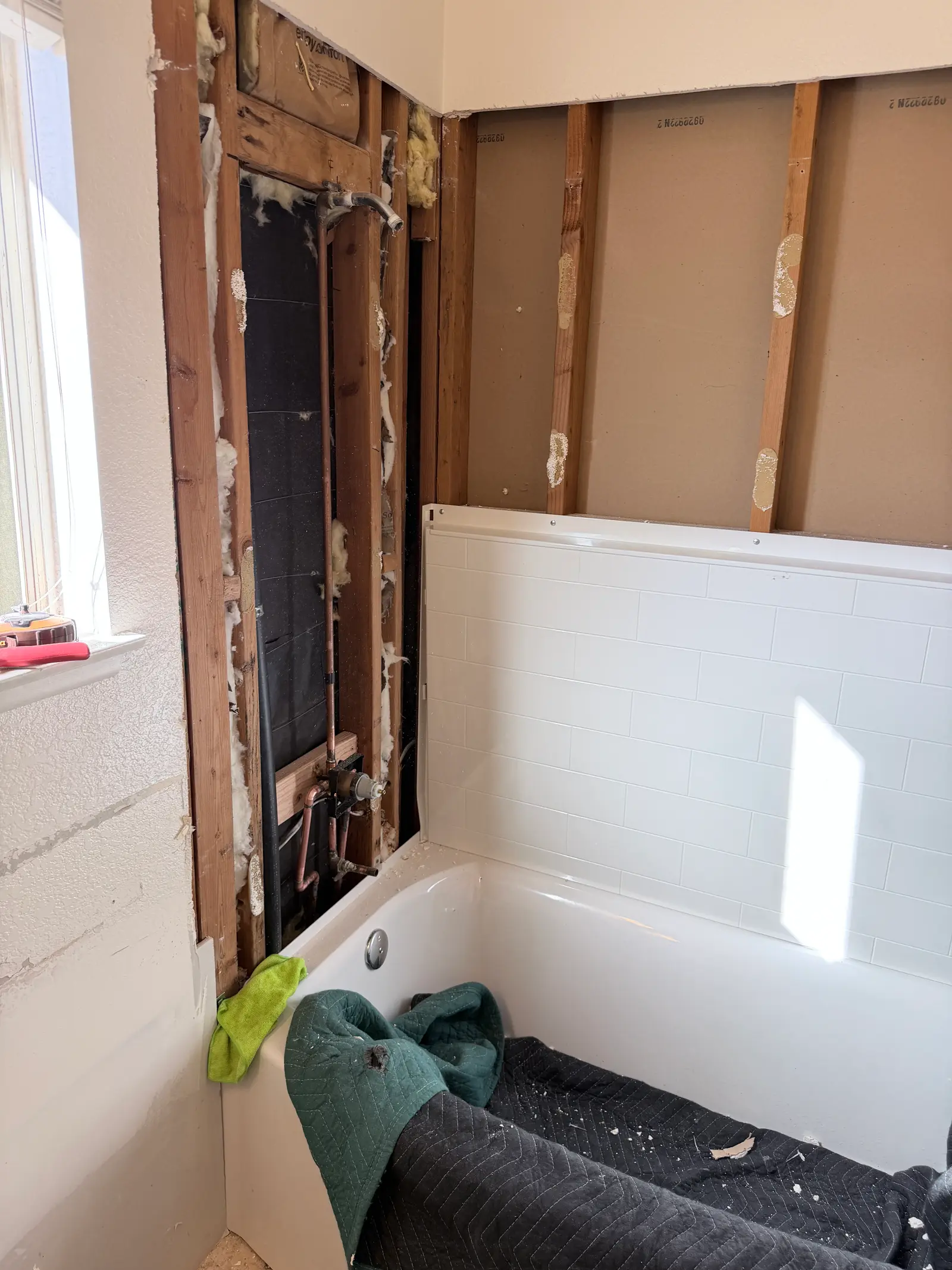 Wall and tub surround repair after toilet drain leak during Temecula water damage restoration project by PL Builders